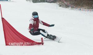 Zdjęcie przedstawia zawodnika dyscypliny snowboard podczas treningu na stoku w Suchem.