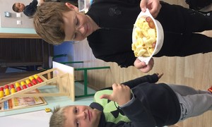 Zdjęcie przedstawia uczniów klasy 2 podczas przygotowywania sałatki owocowej