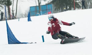 Zdjęcie przedstawia zawodnika dyscypliny snowboard podczas treningu na stoku w Suchem.